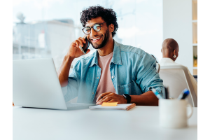 Jovem em ambiente de trabalho moderno, demonstrando confiança após investir em capacitação profissional para aumentar sua empregabilidade.