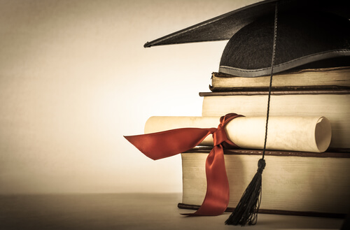 vários livros com um diploma na frente e um capelo de formando vários livros com um diploma na frente e um capelo de formando